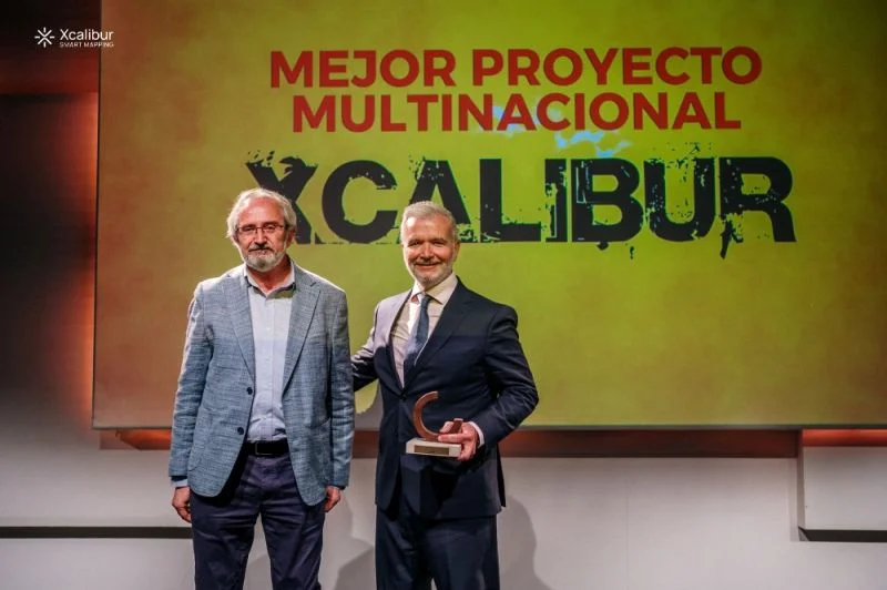 Dos representantes de Xcalibur muestran el premio al mejor proyecto multinacional